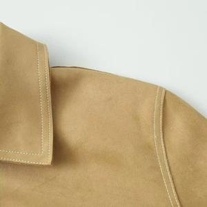 Close-up of contrast white stitching on khaki suede jacket collar and shoulder seams