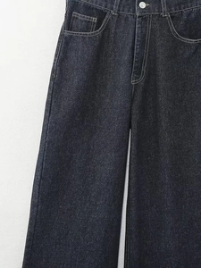 Détail de jean large taille haute en denim foncé avec coutures et bouton métallique