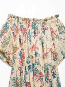 Detail of ramie floral print dress featuring an elastic ruffled neckline and puff sleeves