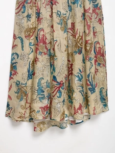 Close-up detail of ramie floral print and tiered pleated hemline on the off-shoulder dress