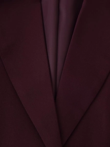 Detail of burgundy suit jacket lapel with premium matte fabric and silky satin lining