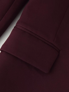 Close-up of deep burgundy blazer sleeve with detailed twill texture and fine stitching