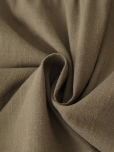 Detailed close-up of dark khaki cotton-linen fabric with rich texture and natural folds