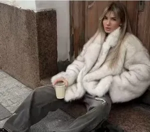 Street style view of a fluffy white faux fur coat featuring an elegant wide collar design