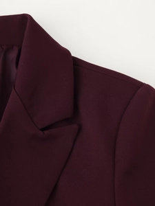 Detail of burgundy blazer showing padded shoulders and sharp notch lapel tailoring