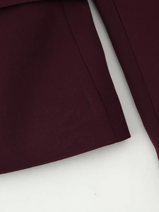 Close-up of premium burgundy woven fabric showing neat stitching on a slim-fit blazer