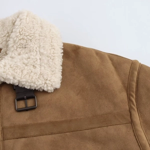 Detail of vintage brown suede jacket featuring sherpa collar and leather buckle strap