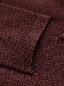 Detail of high-density fine knit fabric with smooth stitching on a burgundy wool sweater