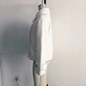 Dettaglio della giacca bianca in pile sherpa con trama spessa e polsini decorativi