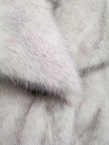 Detailed close-up of fluffy light grey and white faux fur texture with glossy finish