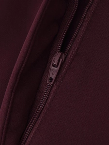 Macro shot of high-quality metal zipper and logo detail on burgundy blazer suit jacket