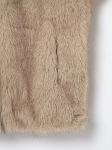 Gros plan sur la texture de fourrure synthétique camel clair aux poils longs et doux