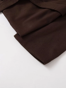 Detail van de donkerbruine blazerstof met dicht weefsel en een stevige afwerking