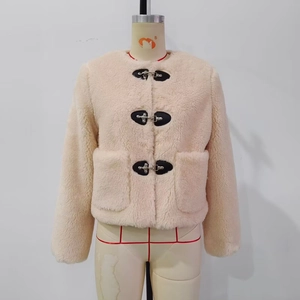 Detail of cream fleece jacket featuring silver metal buckles and black leather trim