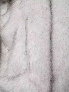 Close-up detail of soft faux fur texture on a grey and white elegant winter coat