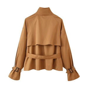 Detail view of brown short trench coat back with storm flap and buckled cuffs