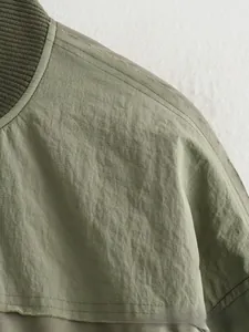 Détail d'un blouson aviateur vert olive avec col côtelé et coutures d'épaules renforcées