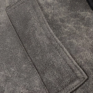 Detalle de tela de cuero sintético gris oscuro desgastado con doble costura en el bolsillo