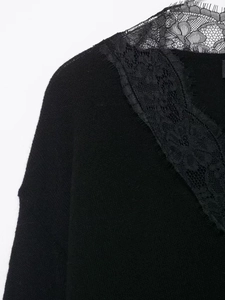 Detail of elegant V-neckline featuring delicate eyelash lace trim on black knit top