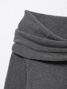 Detail of the soft grey knit fabric and elegant fold design on the off-shoulder collar