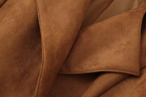 Macro view showing the soft suede texture and premium stitching on the brown jacket collar
