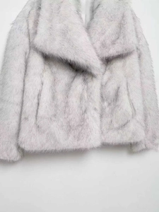 Detailed view of the soft long-haired texture and wide collar on light grey faux fur coat