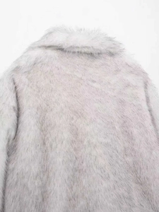 Detail of light gray faux fur coat showing soft plush texture and wide collar back