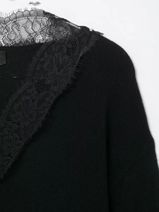 Close-up of elegant black floral lace trim on the V-neck wool blend knit sweater