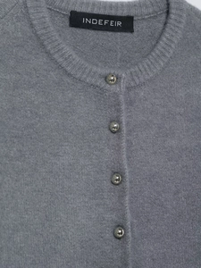 Close-up of grey knit cardigan with silver spherical buttons and INDEFEIR brand label