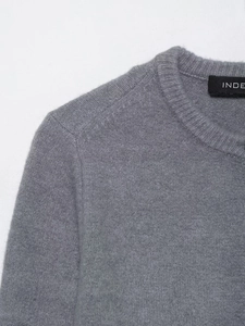 Close-up of crew neck knitwear with soft wool texture and detailed stitching on shoulder