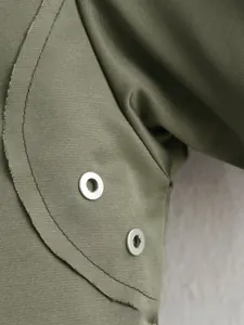 Détail de la veste aviateur vert olive avec tissu sergé et œillets métalliques argentés