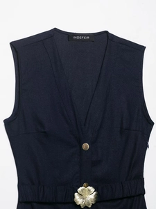 Detail of navy blue V-neck linen dress featuring a golden flower buckle and waist belt