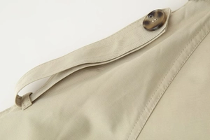Detail of shoulder epaulette on beige cotton twill jacket with marble resin button