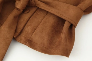 Detailed macro view of brown faux suede jacket with matching fabric-covered buckle and belt