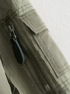 Détail de veste bomber vert olive avec fermeture éclair et coutures à bords francs