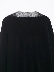 Detail shot of the delicate black floral lace stitching on the neckline of this knit top