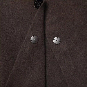 Macro shot of dark coffee wool blazer featuring gunmetal snap button and sequin detail