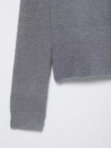 Close-up of grey knit cardigan showing fuzzy texture and ribbed cuffs detail
