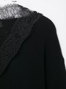 Gros plan du haut en maille noire avec des détails délicats en dentelle florale au col
