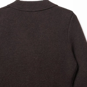 Close-up of dark brown knit blazer showing fine stitching and high-quality wool texture