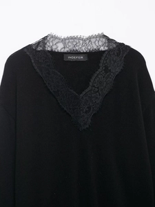 Détail du pull en laine mélangée noire avec une élégante bordure en dentelle fleurie au col