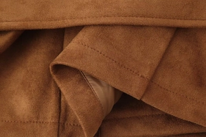 Close-up of premium brown faux suede fabric texture and professional stitching details