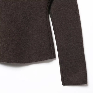 Detailed close-up of dark brown knitted blazer texture and high-quality sleeve stitching
