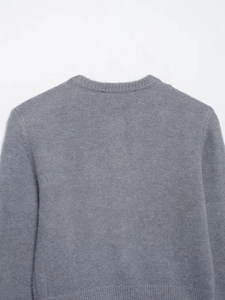 Close-up of the back collar and shoulder seams of a minimalist grey fine-knit sweater