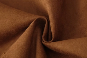 Close-up of premium brown faux suede fabric showing soft texture and fine grain detail