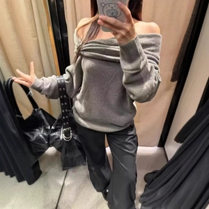 Off-shoulder grey knit top with twist detail and black wide-leg pants for a casual look