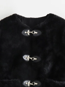 Detail view of metal toggle closures and black faux fur texture on a fleece jacket