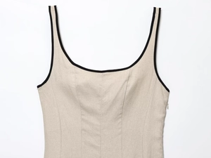 Close-up of linen midi dress featuring black contrast piping and side zipper detail