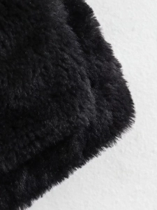 Macro detail of soft black faux fur texture on a warm winter fleece jacket for women