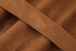 Detail of premium caramel brown faux suede fabric with precise stitching on the jacket